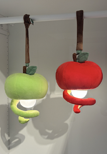 Green and red apple plush pendant lamps hanging on a wall